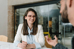 Femme avec une blouse, une veste et des lunettes à un entretien d'embauche