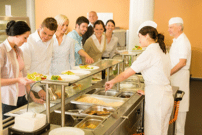Employé de restauration sert des plats dans une cantine
